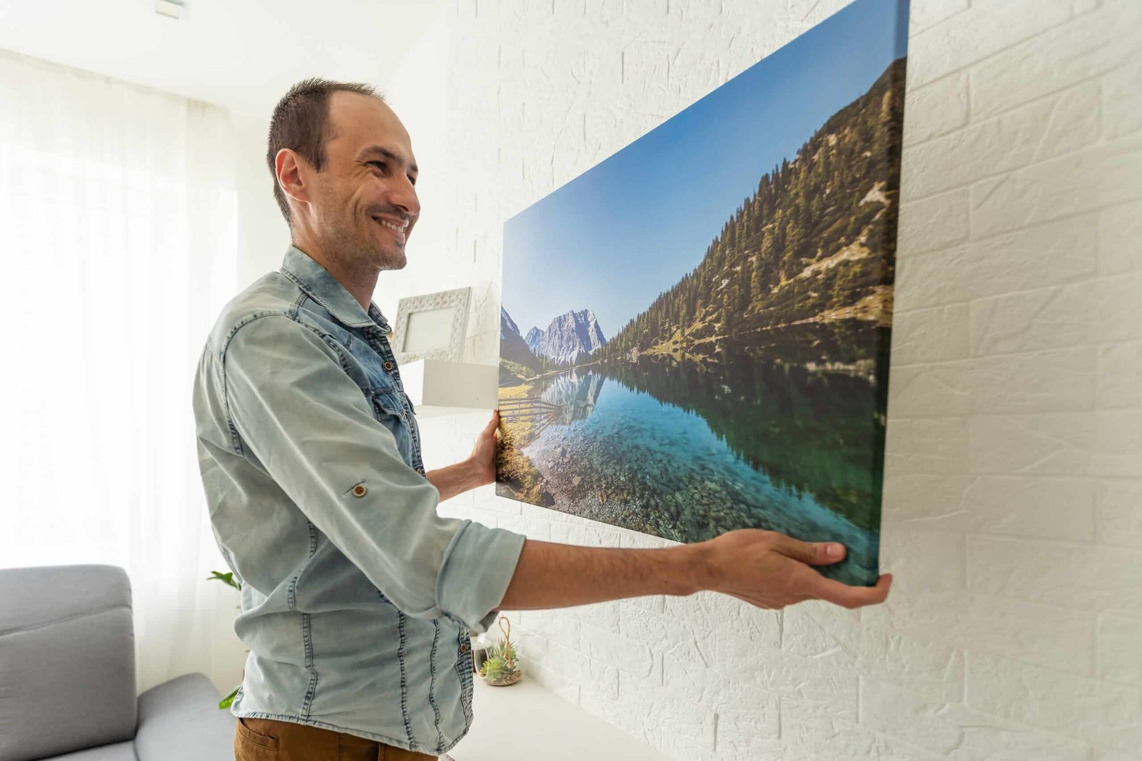 man holds canvas in the interior